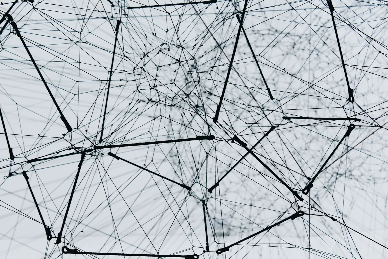 A dense tangle of black threads strung between nodes against a white background
