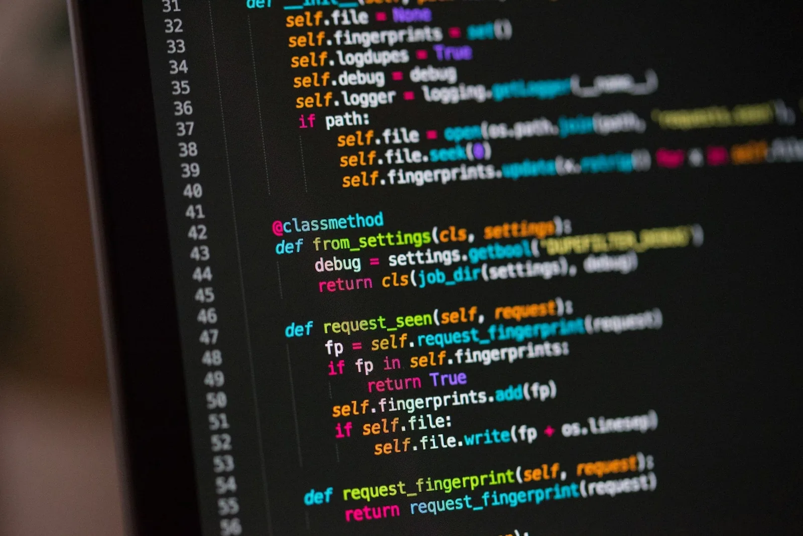 A close-up of a monitor showing syntax-highlighted Python source on a dark theme